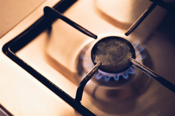 burning gas stove with light in dark room, closeup.