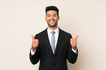 Young handsome businessman man over isolated background giving a thumbs up gesture
