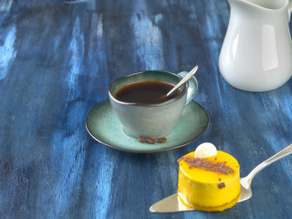 Porcelain cup with black coffee and shortbread.Are worth on backdrop of cold tones. 