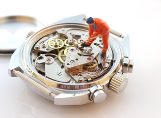 close up macro pic of toy figurine repairing vintage chronograph watch mechanism