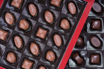 Brown chocolate candy background. Assortment of chocolate candies sweets in the box