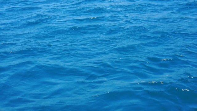 The surface of the blue sea, ocean waves on a sunny day with sunlight on the surface. Background of blue ocean surface.1920X1080 Full Hd.
