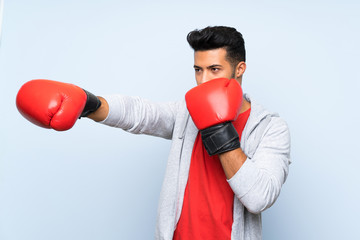Sport man with boxing gloves over isolated blue wall