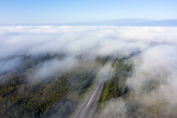 Beautiful hight way road high angle beautiful view of the fog over the road on an early summer morning in central Russia. Bird's eye view of the road and skyline.