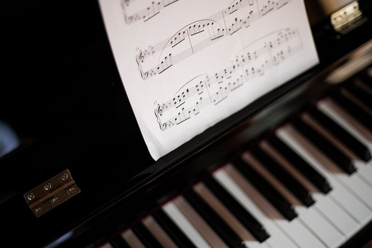 Closeup of a piano keyboard and a music sheet
