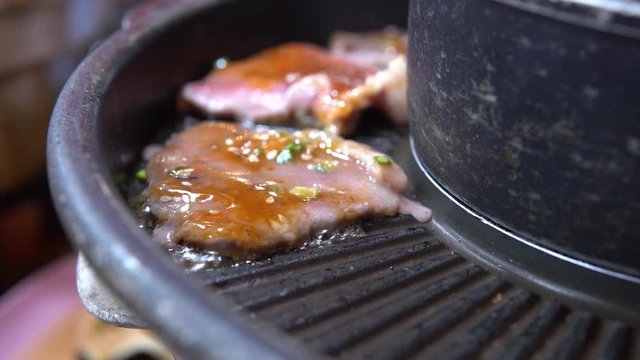 frying pan with meat toppping with spices.