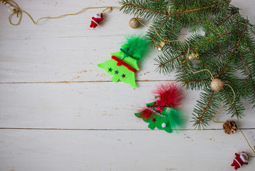 New year's decoration. A branch of green spruce. Decorative Christmas trees on a white wooden background. Copyspace