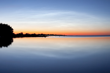 Naklejka na ściany i meble Sunset over ocean horizon. The blue hour in the swedish summer evening at the island of Gotland.