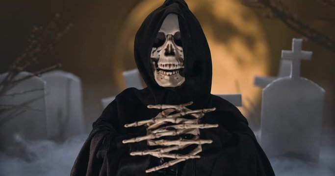 Animation of a talking skeleton with black scarf stop motion footage on a cemetery background with fullmoon.
