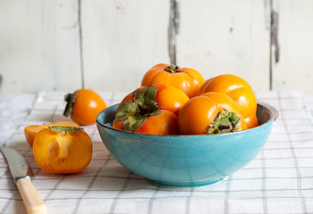 ripe fresh persimmons fruit, in a plate isolated on white background