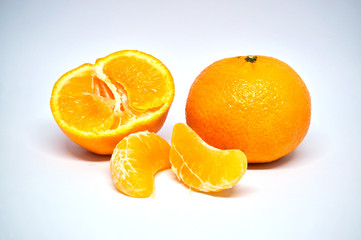 Je eine ganze und halbierte Mandarine, dazu noch zwei Fruchtspalten, freigestellt