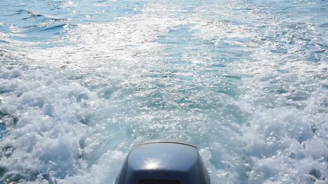 Outboard motor creates waves on the surface of the ocean. Trace of foamy water on the surface of the ocean due to outboard motor on a boat.1920X1080 Full Hd.