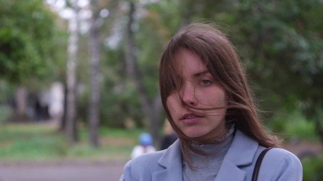 Serious look of girl with windy hair at dark street