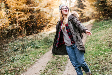 Hiking and travel along in the forest. Concept of trekking, adventure and seasonal vacation. Young woman walking in woods.