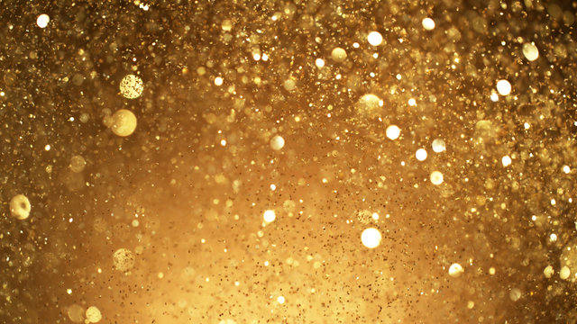 Abstract golden glittering background with blur dots.