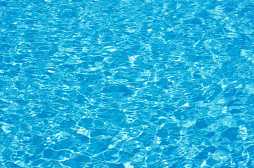 Blue pool water with sun reflections