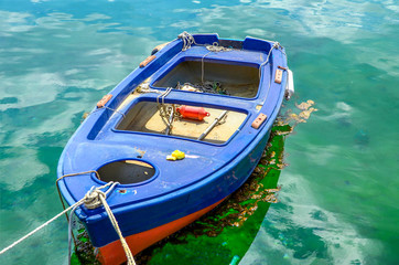 Obraz na płótnie Canvas Small fishing boat floating in green waters