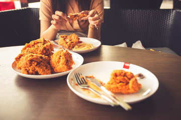 Close-up Fried chicken,freshfast on plate with fried chicken blur background,Woman eating fried chicken,Hungry,diet,Fat food,healthy food