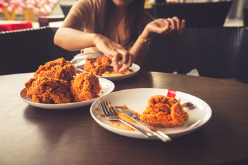 Close-up Fried chicken,freshfast on plate with fried chicken blur background,Woman eating fried chicken,Hungry,diet,Fat food,healthy food