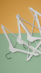 Wooden coat hangers / clothes hanger on a green and yellow background. Vertical concept for sale