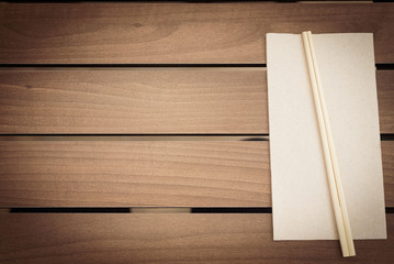 ..Brown wooden plank table background with white napkin and Japanese chopsticks