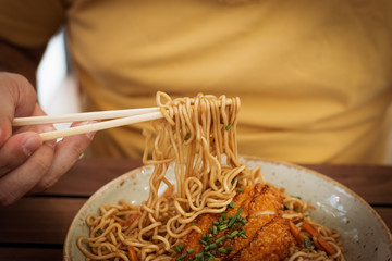 Thai food. Poultry noodles on a brown wooden planks table in an ethnic dish