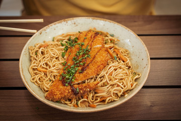 Thai food. Poultry noodles on a brown wooden planks table in an ethnic dish