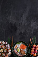 Assorted sushi set on dark slate background. Sushi maki roll with salmon, scallop, eel and prawn...
