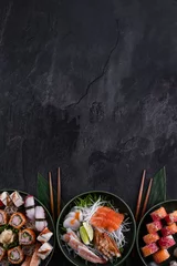 Foto op Canvas Assorted sushi set on dark slate background. Sushi maki roll with salmon, scallop, eel and prawn sashimi served with daikon radish. Copy space for text. Restaurant menu. Traditional japanese food. © CrunchyBeans