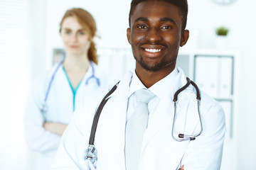 Fototapeta premium Happy african american doctor with medical staff at the hospital. Multi ethnic people group