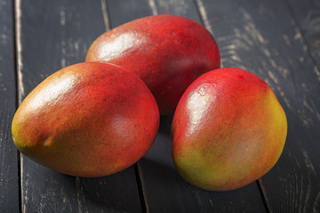 Mango fresh fruit on black wooden table.