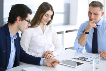 Obraz premium Group of business people discussing questions at meeting in modern office. Managers at negotiation or brainstorm. Teamwork, partnership and business concept