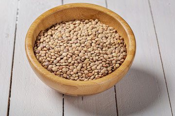Uncooked green lentils on wooden black table