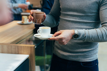 close up of man hands holding cup of coffee