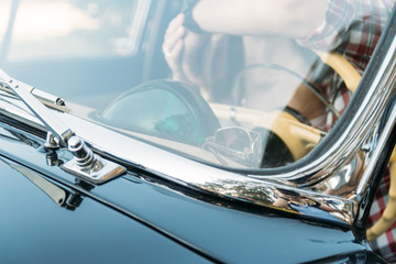 Obraz premium the man is sitting at the wheel, the driver. view from the rear window. Rear view of tourist guy in car. Travel and summer vacation concepts.