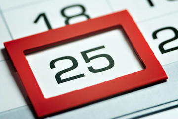 twenty-fifth of the month highlighted on the calendar with a red frame close-up macro, mark on the calendar, twenty-fifth date