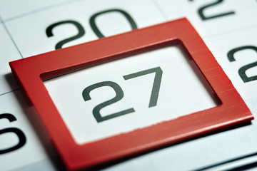 twenty-seventh of the month highlighted on the calendar with a red frame close-up macro, mark on the calendar, twenty-seventh date