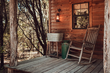 Fototapeta na wymiar Rocking chair on the cabin front porch in the woods