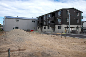 Fototapeta na wymiar 住宅の建設現場とアパートの建物