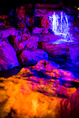 Neon Cave Rocks and Stream of Water