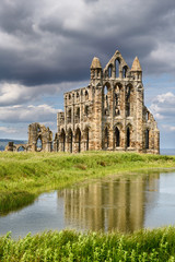 Obraz premium Gothic ruins of 13th Century Whitby Abbey on the North Sea reflected in the Abbey Pond Whitby North York Moors National Park England