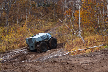 Obraz na płótnie Canvas all-terrain vehicle with big wheels overcoming a dirty road
