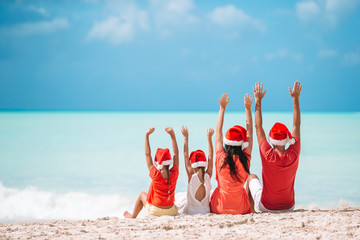 Happy family with two kids in Santa Hat on summer vacation