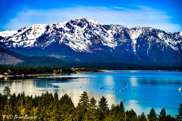Lake Tahoe in the spring with snow covered Sierra Nevada Mountains - obrazy, fototapety, plakaty