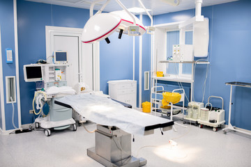 Operation table with large lamps above inside contemporary surgery room