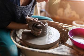 Woman making ceramic work with potter's wheel