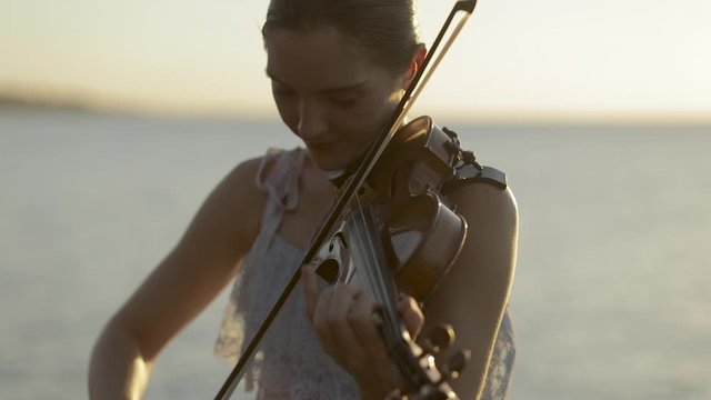 Violinist by Lake at Sunset