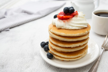 Breakfast wih Pancakes, cream, berry and coffee cup isolated on white background, copy space for text.