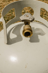 Vertical frame of an angled overhead close-up of the top of a white propane tank