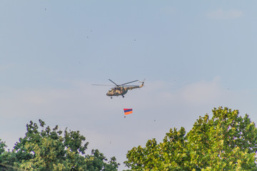Fototapeta na wymiar YEREVAN, ARMENIA - JULY 5, 2017: Helicopter carrying the national flag of Armenia during the celebrations of the Constitution Day and Day of State Symbols in Yerevan, capital of Armenia
